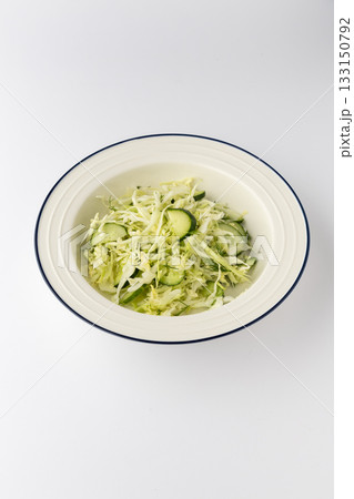 Fresh cabbage and cucumber salad with dill in a bowl on white background Fresh cabbage and cucumber salad with dill in a bowl on white background 133150792