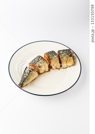 Baked mackerel slices with tomato and sesame on a white plate, isolated 133150799