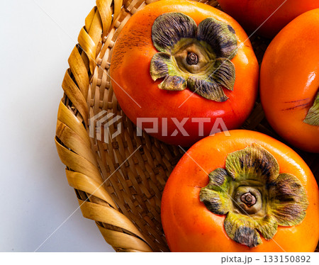 白背景と笊に入った真っ赤な柿 133150892
