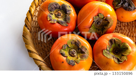 白背景と笊に入った真っ赤な柿 133150896