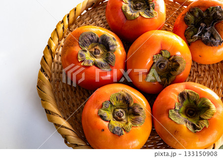 白背景と笊に入った真っ赤な柿 133150908