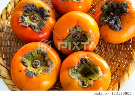 白背景と笊に入った真っ赤な柿 白背景と笊に入った真っ赤な柿 133150909