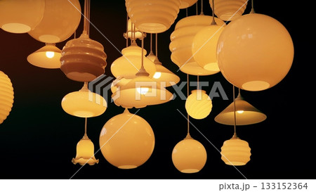 Group of decorative pendant lamps with warm light hanging from the ceiling in a modern interior, creating cozy ambient lighting Group of decorative pendant lamps with warm light hanging from the ceiling in a modern interior, creating cozy ambient lighting 133152364