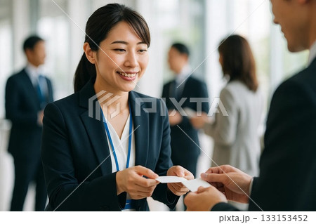 オフィスで名刺交換をする笑顔の日本人ビジネス女性 133153452