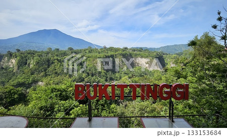 A stunning viewpoint at Panorama Ngarai Sianok showcases lush greenery, towering trees, and a majestic mountain under the clear blue sky, offering a peaceful harmony. A stunning viewpoint at Panorama Ngarai Sianok showcases lush greenery, towering trees, and a majestic mountain under the clear blue sky, offering a peaceful harmony. 133153684