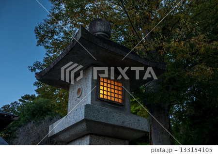 夕暮れに灯る神社の石灯篭 133154105