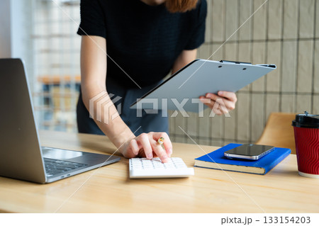 Close up of businesswoman or accountant hand typing laptop working to calculate on desk about cost Close up of businesswoman or accountant hand typing laptop working to calculate on desk about cost 133154203