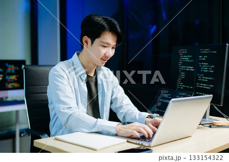 Asian software developer working late with code on screens, tablet, and phone. Concept of programming, tech lifestyle, 133154322