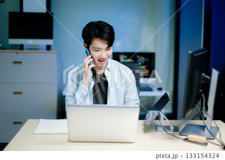 Asian software developer working late with code on screens, tablet, and phone. Concept of programming, tech lifestyle, 133154324