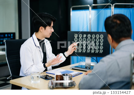 Friendly doctor discussing brain scan results with patient on screen. Health consultation, neurology, diagnosis, and care in clinic Friendly doctor discussing brain scan results with patient on screen. Health consultation, neurology, diagnosis, and care in clinic 133154427