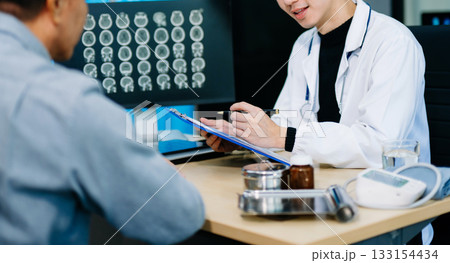 Doctor discusses brain scan results with patient using screen and clipboard. health care, neurology, diagnosis Doctor discusses brain scan results with patient using screen and clipboard. health care, neurology, diagnosis 133154434