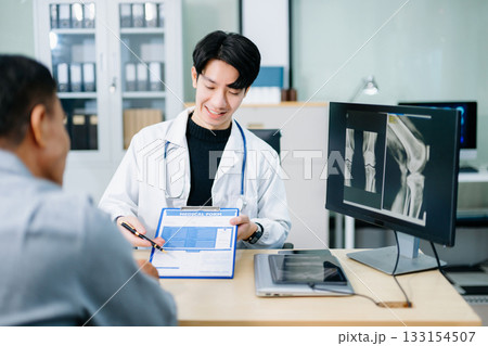 Doctor consulting patient using medical form and X-ray scan in clinic. Ideal for themes of diagnosis, health insurance, communication Doctor consulting patient using medical form and X-ray scan in clinic. Ideal for themes of diagnosis, health insurance, communication 133154507