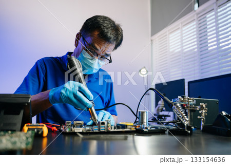 Skilled technician in lab coat and gloves recovers data from hard disk. Skilled technician in lab coat and gloves recovers data from hard disk. 133154636