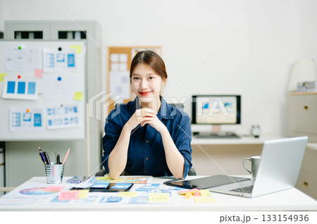 designer gestures confidently at her creative workspace, showcasing positivity, communication, and professional energy designer gestures confidently at her creative workspace, showcasing positivity, communication, and professional energy 133154936