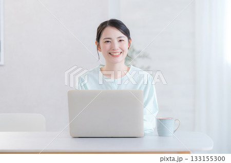 自宅やカフェでパソコンをする笑顔のかわいい女性　カメラ目線 133155300