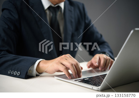 Close-up of hands typing on laptop in a dark workspace. Concept of work focus, remote job, or programming technology digital transformation, and smart work solutions. Close-up of hands typing on laptop in a dark workspace. Concept of work focus, remote job, or programming technology digital transformation, and smart work solutions. 133158770
