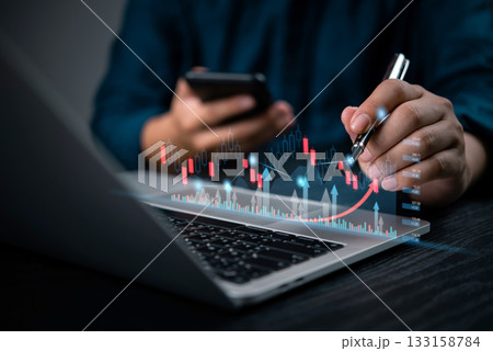 Businessman analyzing stock market data analysis with digital charts on laptop and smartphone, financial trends, forex trading strategies, and investment growth. 133158784