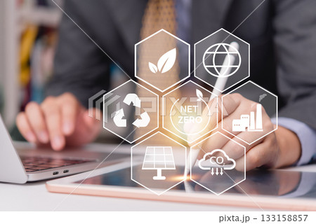 Businessman using tablet to plan ESG and net zero strategy with clean energy and carbon reduction icons for sustainable development goals.CO2 emission reduction, green energy, and environmental 133158857