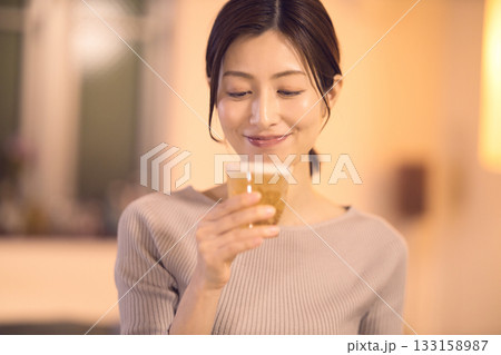 ビールを飲みながら夕食をとるミドル女性 ビールを飲みながら夕食をとるミドル女性 133158987