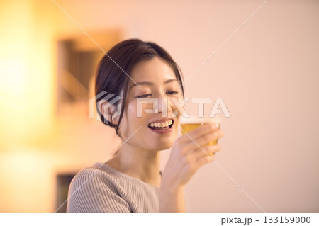 ビールを飲みながら夕食を食べるミドル女性 ビールを飲みながら夕食を食べるミドル女性 133159000