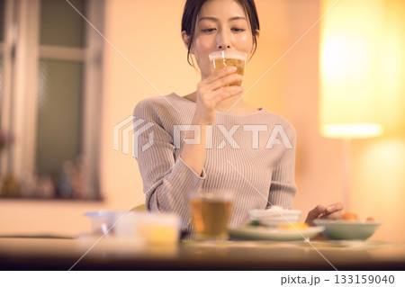 ビールを飲みながら夕食を食べるミドル女性 ビールを飲みながら夕食を食べるミドル女性 133159040