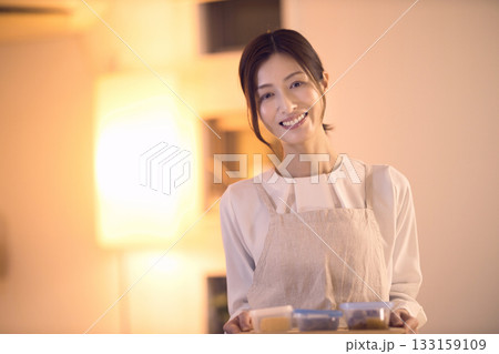 お夕食をテーブルに運ぶミドル女性  133159109