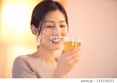 ビールを飲みながら夕食を食べるミドル女性 133159231