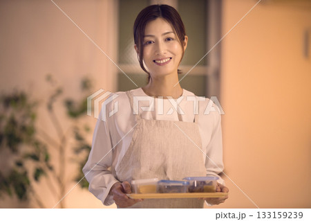 お夕食をテーブルに運ぶミドル女性 お夕食をテーブルに運ぶミドル女性 133159239