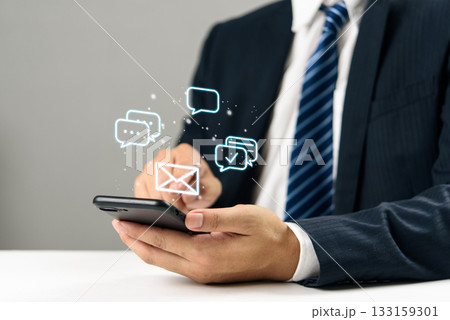 Businessman hand holding smartphone with digital chat and email icons, communication online messaging, social media, mobile marketing, and modern customer engagement technology. Businessman hand holding smartphone with digital chat and email icons, communication online messaging, social media, mobile marketing, and modern customer engagement technology. 133159301