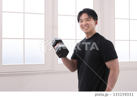 ダンベルで筋トレをする20代男性 133159331