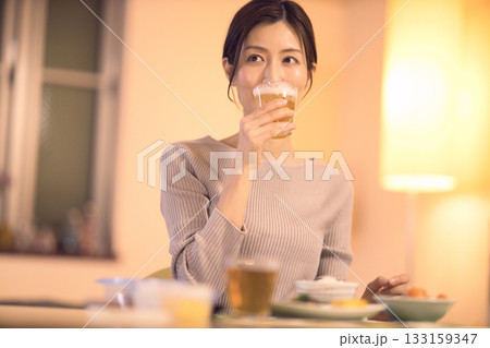 ビールを飲みながら夕食を食べるミドル女性 ビールを飲みながら夕食を食べるミドル女性 133159347
