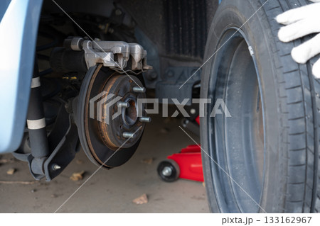 車のタイヤ交換と整備 メンテナンス (タイヤ交換をする男性の手) 車のタイヤ交換と整備 メンテナンス (タイヤ交換をする男性の手) 133162967