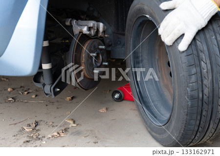 車のタイヤ交換と整備　メンテナンス　（タイヤ交換をする男性の手） 133162971