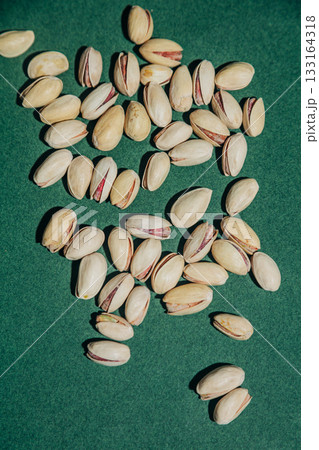 Salted pistachios in shells green background Salted pistachios in shells green background 133164318