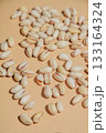 Salted pistachios in their shells are scattered on a soft beige background 133164324