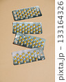 Blister packs with capsules for treating bloating are neatly arranged on a beige background 133164326