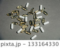 Transparent fish oil capsules alongside white iron capsules 133164330