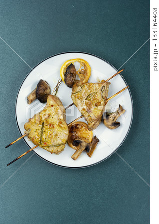 Baked tuna with mushrooms, kebabs. 133164408