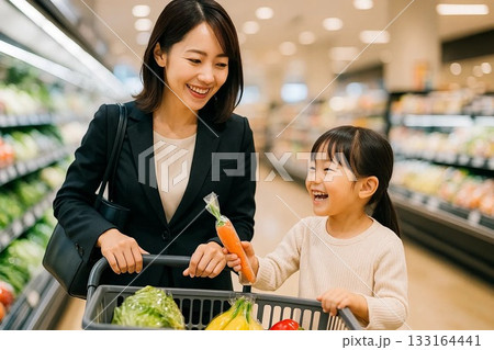 娘と一緒にスーパーで買い物する母親 133164441