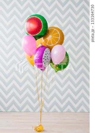 Colorful Fruit Balloons On Floor Against Zigzag Wall 133164730