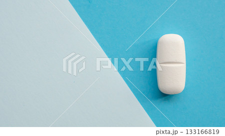 White medicine pill tablet on blue and white background 133166819