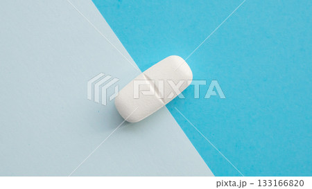 White medicine pill tablet on blue and white background 133166820
