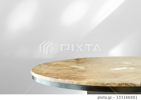 Round marble table top with abstract shadow drop on white wall background for mockup product display Round marble table top with abstract shadow drop on white wall background for mockup product display 133166881
