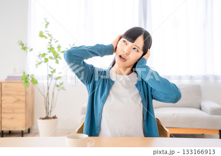 耳を塞ぐ若い女性 133166913
