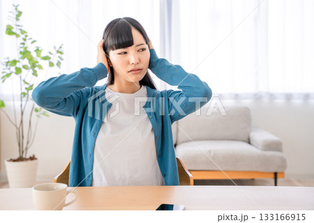 耳を塞ぐ若い女性 133166915