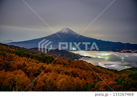 【山梨県】河口湖の湖上を覆う雲海と落葉松林の向こうに富士山 133167469