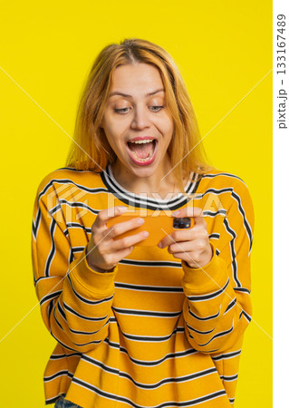 Happy woman playing racing drive simulator shooter video games on smartphone celebrate victory win Happy woman playing racing drive simulator shooter video games on smartphone celebrate victory win 133167489