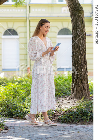 Tourist traveler young woman using smartphone search a way on map in navigator app on city street Tourist traveler young woman using smartphone search a way on map in navigator app on city street 133167591
