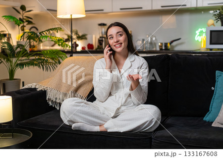 Young woman enjoys smartphone call dialogue smiles talk with friend shares news gossip clear voice 133167608