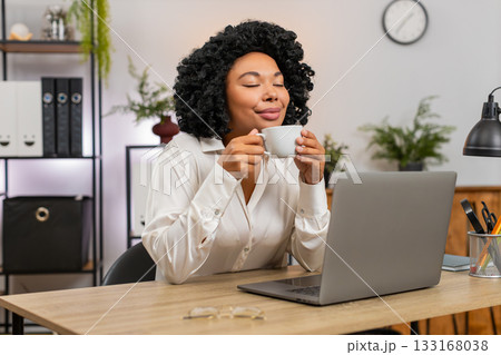 African American businesswoman drinks coffee thinking near window resting from work for inspiration 133168038